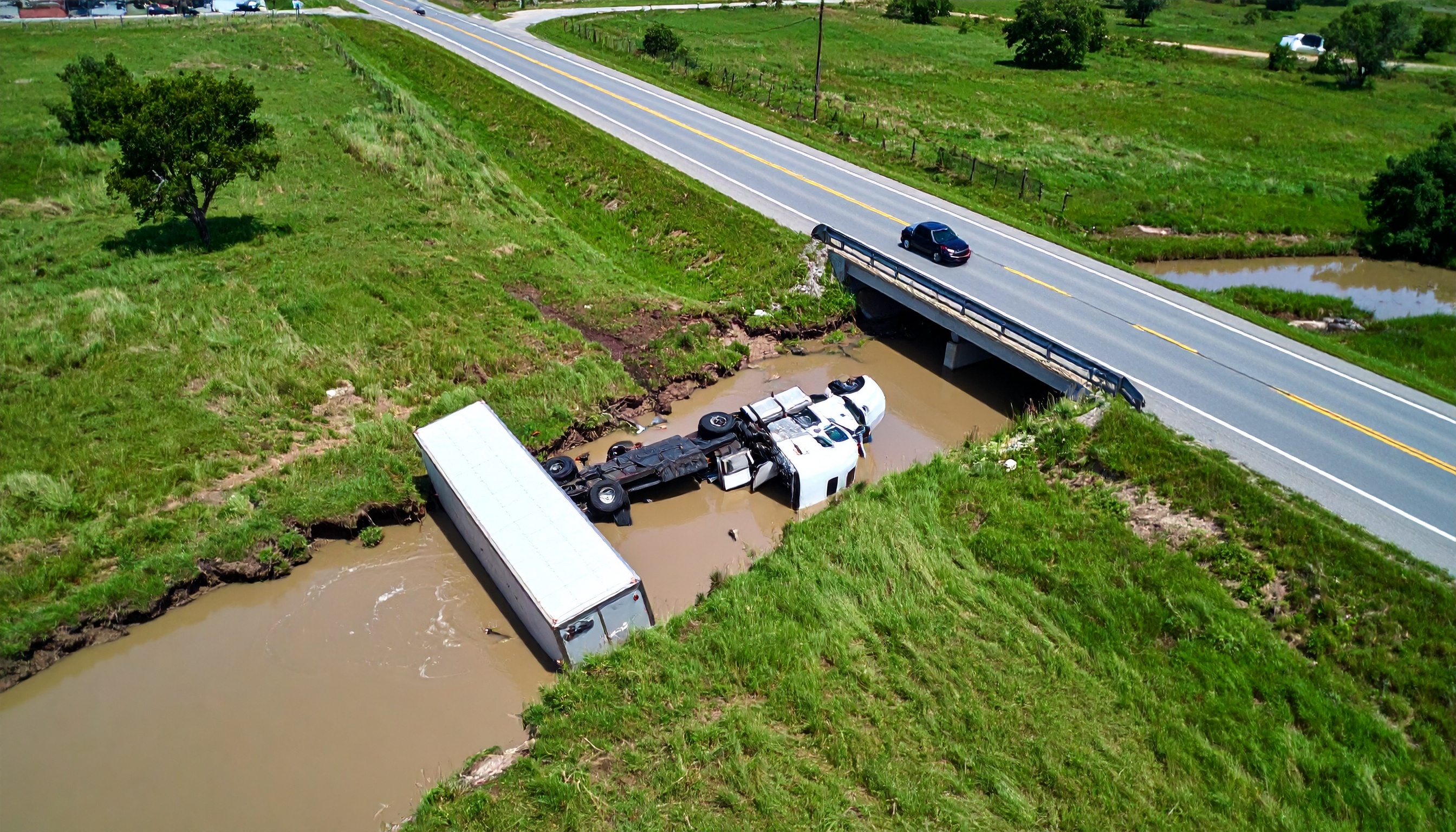 Firefly_a truck that has rolled over into a ditch on its side lying flat in the united state 80607